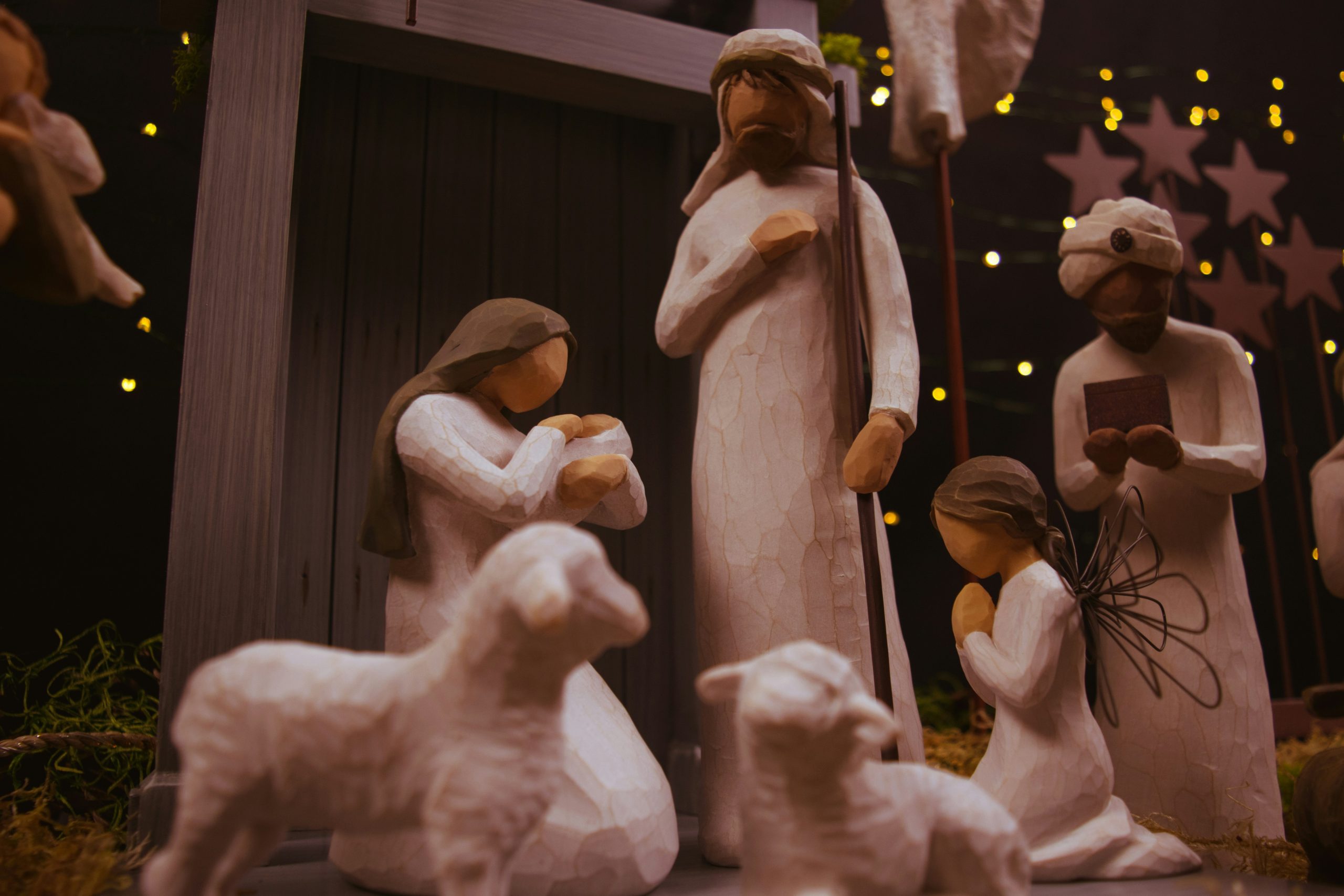 Nativity scene with carved figures of Mary holding baby Jesus, Joseph, a wise man, an angel and sheep